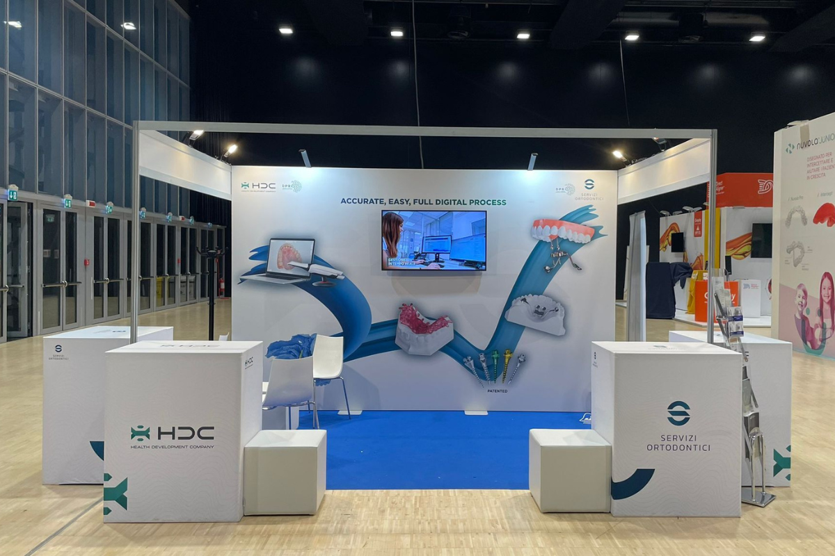 Stand HDC Servizi Ortodontici con desk e fondale a un appuntamento congressuale